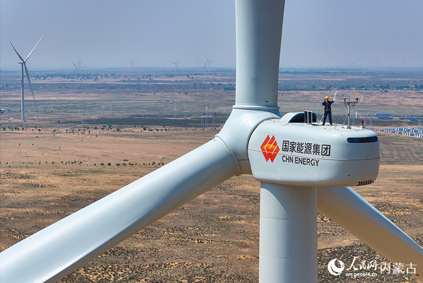 5月23日,工人在鄂爾多斯市鄂托克前旗30萬千瓦上海廟風電場調試設備(無人機照片)。王正攝