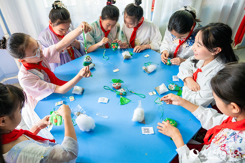 內蒙古呼和浩特市玉泉區恒昌店巷小學學生在“繽紛端午 粽享童趣”主題活動現場體驗制作香囊。丁根厚攝