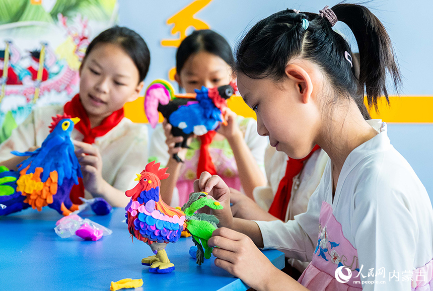 內蒙古呼和浩特市玉泉區恒昌店巷小學學生在“繽紛端午 粽享童趣”主題活動現場制作“端午雄雞”。丁根厚攝