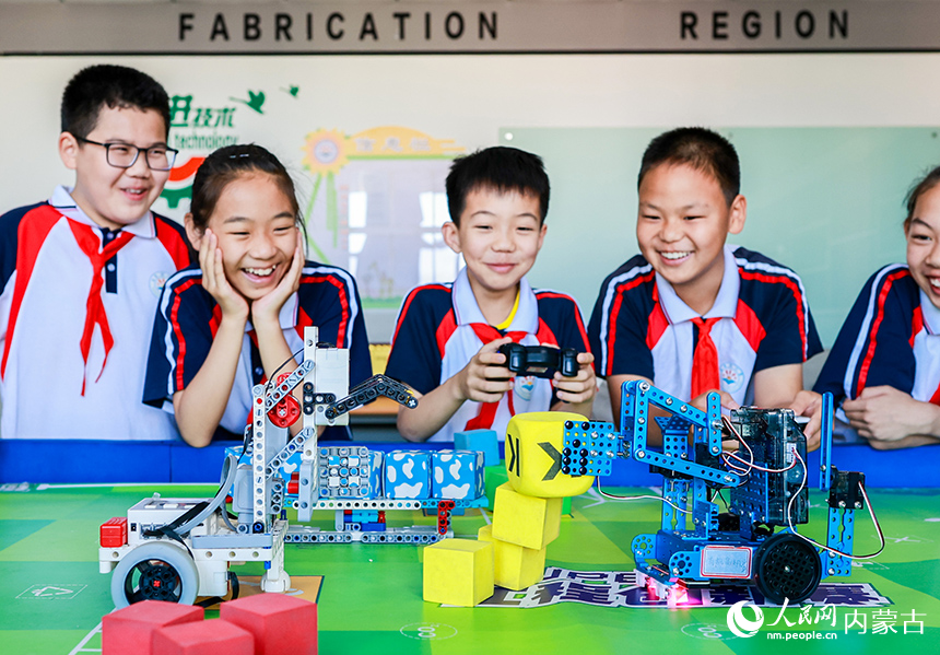 呼和浩特市玉泉區石東路小學學生在操控編程機器人完成任務。丁根厚攝