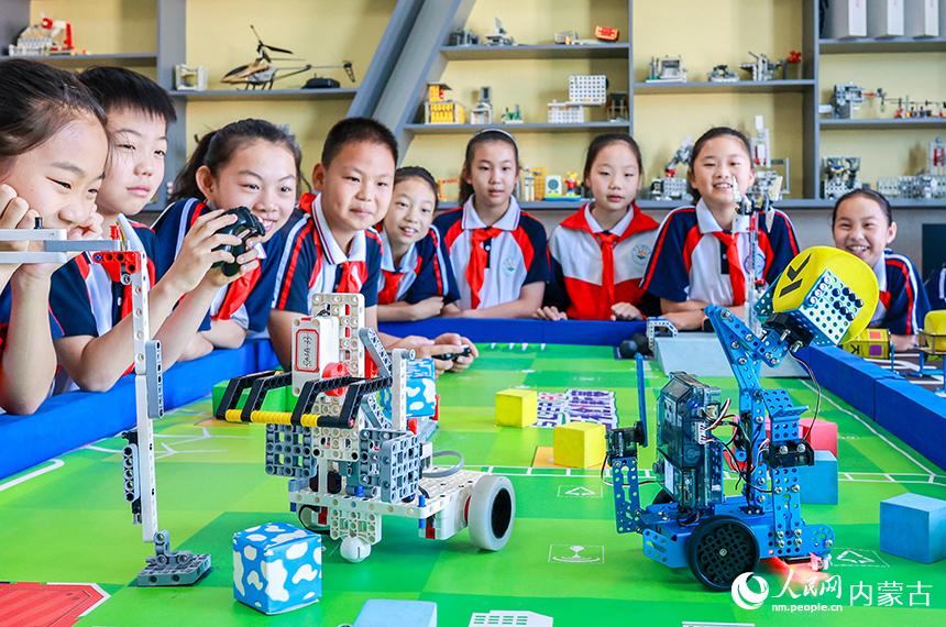 呼和浩特市玉泉區石東路小學學生在操控編程機器人完成任務。丁根厚攝