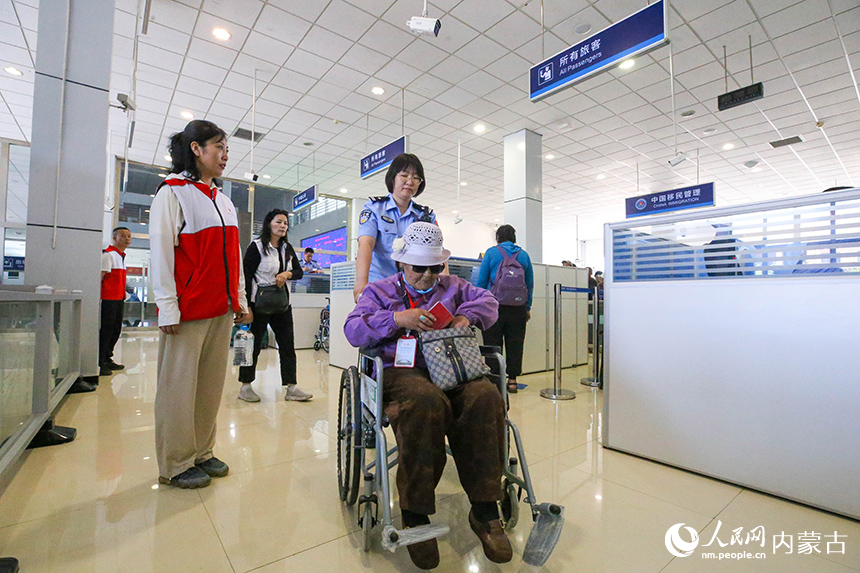 二連出入境邊防檢查站移民管理警察為參加“一帶一路·光明行”的蒙古國患者提供高效貼心的通關服務。楊金燁攝