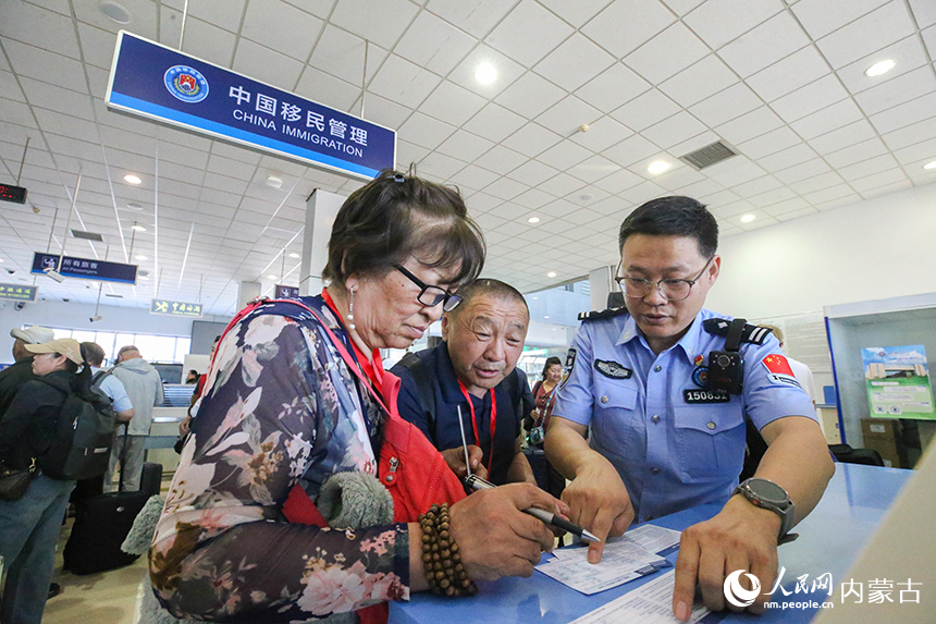 二連出入境邊防檢查站移民管理警察為參加“一帶一路·光明行”的蒙古國患者提供通關咨詢。楊金燁攝