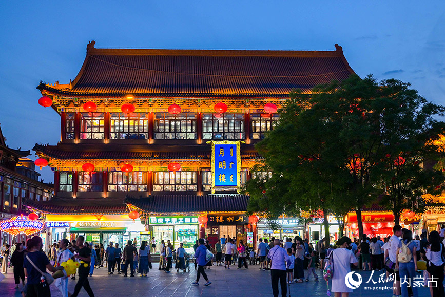 6月24日，游客在呼和浩特市玉泉區(qū)塞上老街旅游休閑街區(qū)“月明樓”前游玩。丁根厚攝