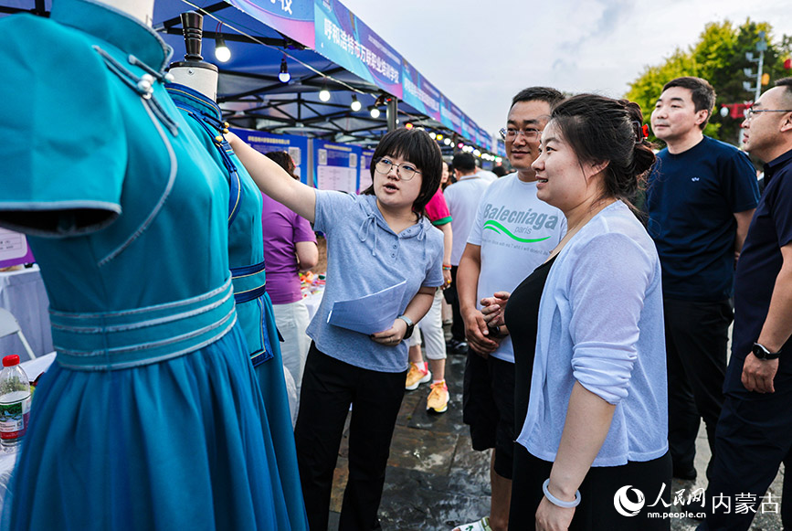 6月28日晚，工作人員在呼和浩特市玉泉區“人才夜市”專場招聘會現場向求職者介紹職業技能培訓項目。丁根厚攝