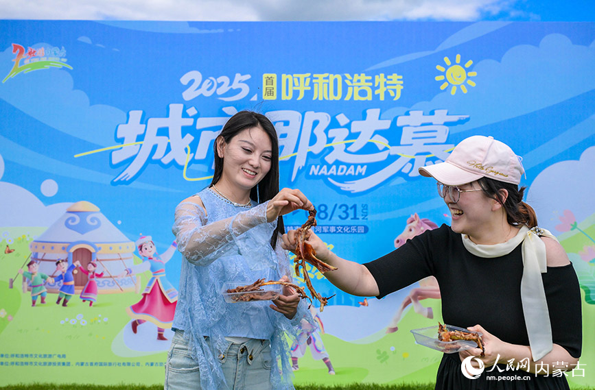 7月5日，游客在呼和浩特城市那達慕活動現(xiàn)場品嘗烤全羊。丁根厚攝