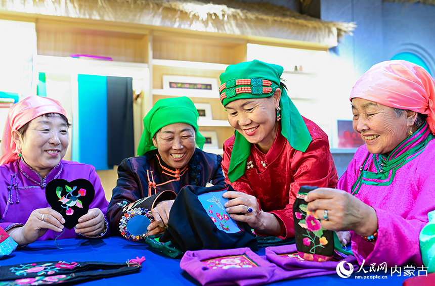 科爾沁右翼前旗烏蘭毛都蘇木牧民在薩日郎巾幗民族手工藝品專業合作社交流刺繡技藝。王正攝
