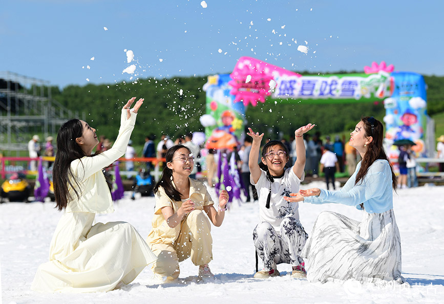 7月11日，游客在呼倫貝爾市牙克石市鳳凰山景區(qū)戲雪。王正攝