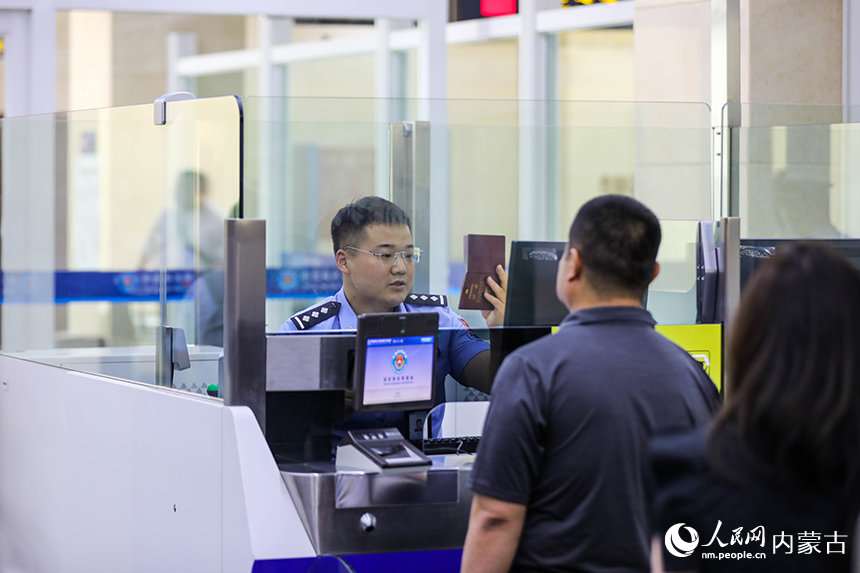 二連出入境邊防檢查站移民管理警察為入境航班旅客辦理通關手續。楊金燁攝