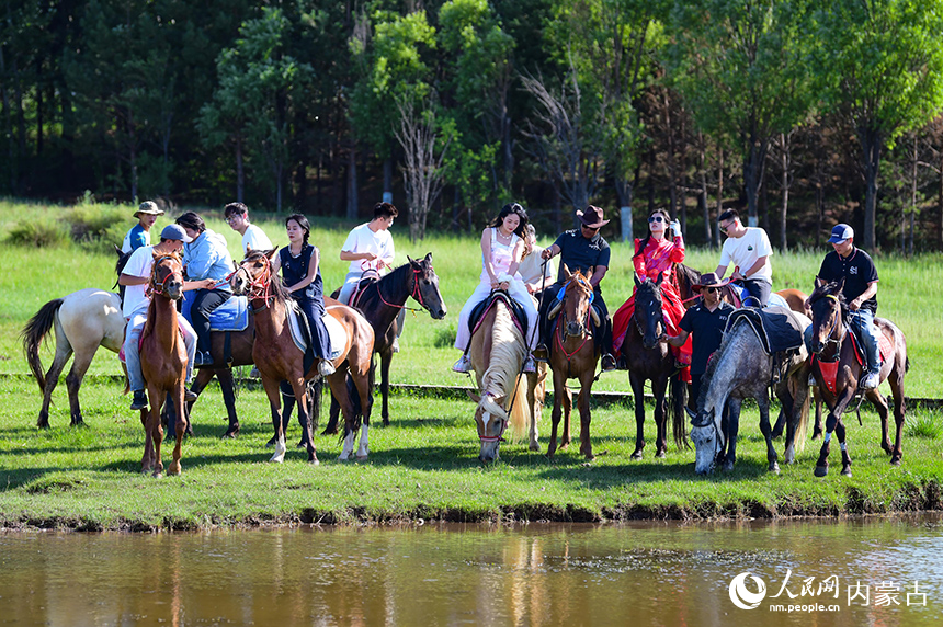 游客騎馬在鄂爾多斯市伊金霍洛旗鄂爾多斯文化產業園景區古城海子濕地游覽。王正攝