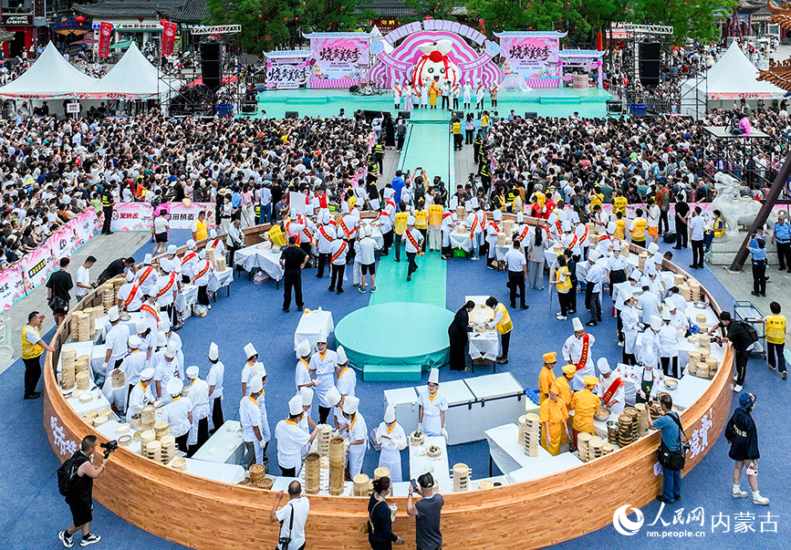 7月19日，游客在呼和浩特市玉泉區(qū)塞上老街旅游休閑街區(qū)參加燒賣美食季活動(dòng)。丁根厚攝