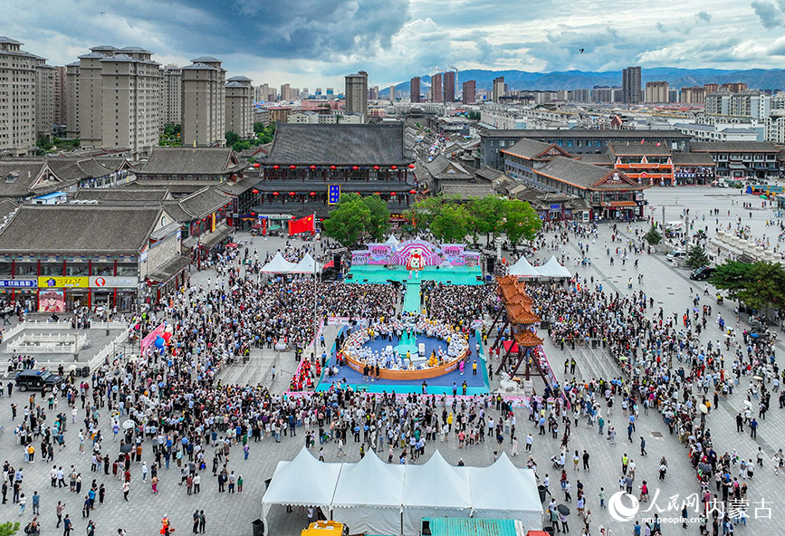 7月19日,游客在呼和浩特市玉泉區塞上老街旅游休閑街區參加燒賣美食季活動。丁根厚攝