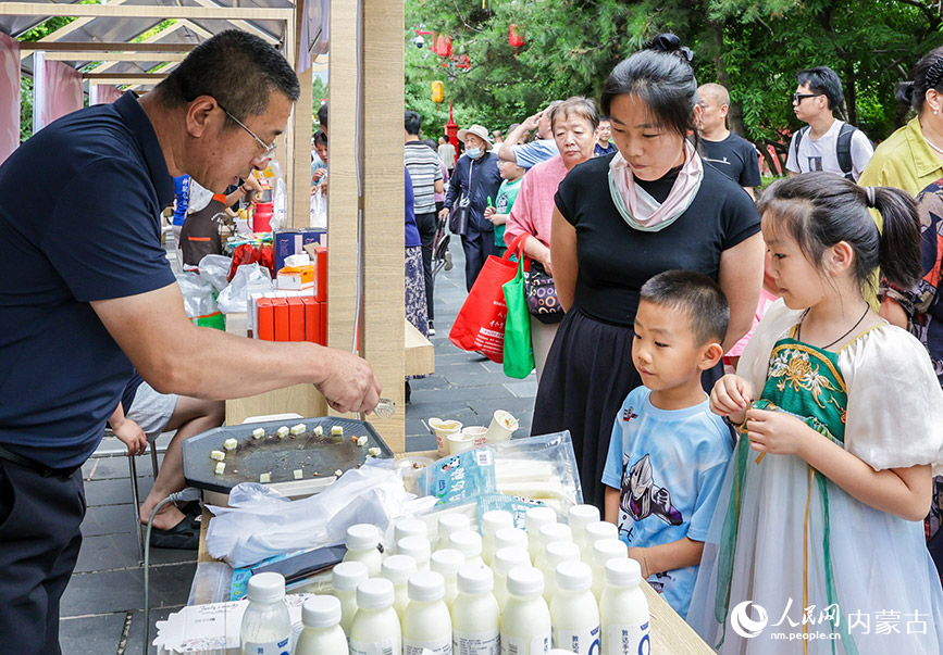 7月19日,游客在呼和浩特燒賣美食季活動現場選購、品嘗內蒙古名小吃。丁根厚攝