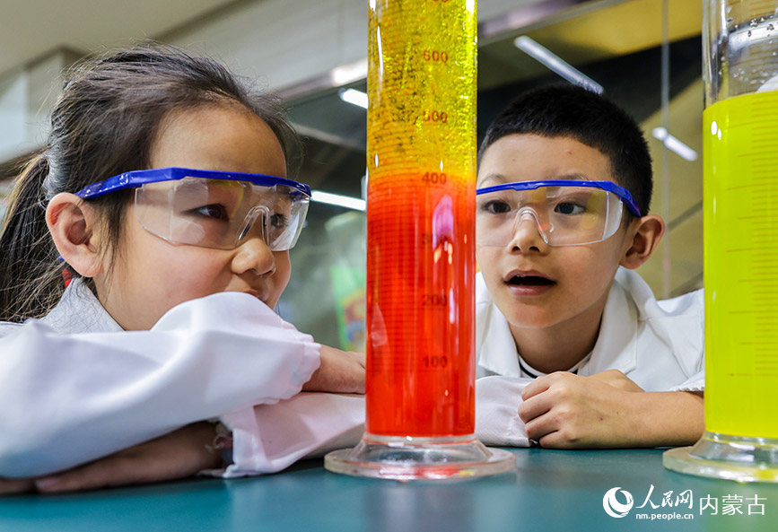 7月20日，孩子們?cè)趦?nèi)蒙古呼和浩特市玉泉區(qū)青少年宮科學(xué)課上體驗(yàn)科學(xué)秀項(xiàng)目。丁根厚攝