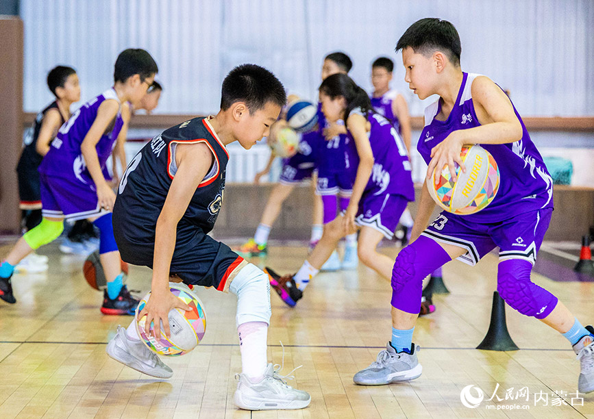 7月27日，孩子們在呼和浩特市玉泉區制鎖廠勱立體育文化產業園籃球中心進行運球訓練。丁根厚攝