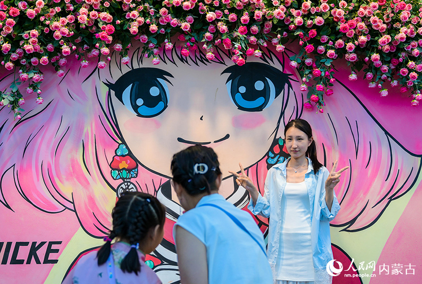 游客在呼和浩特市玉泉區塞上老街旅游休閑街區一處花墻微景觀前拍照打卡。丁根厚攝