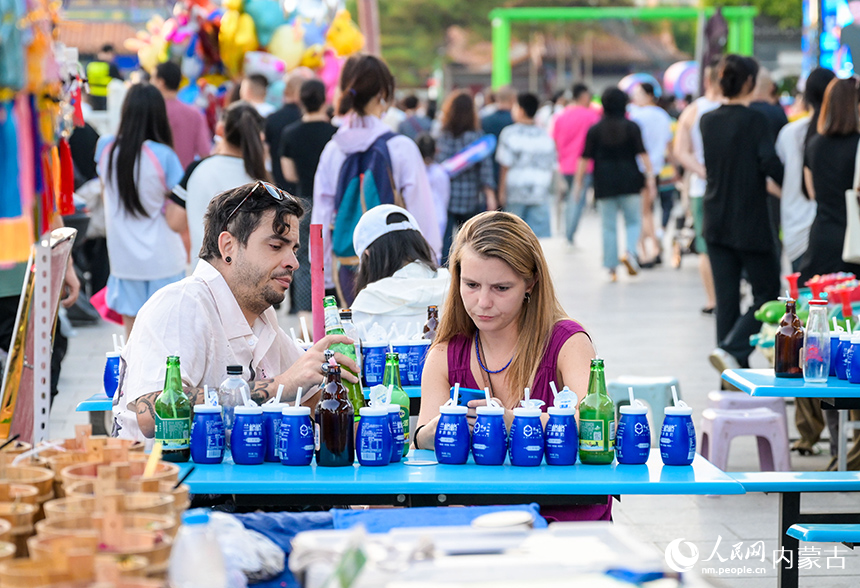 外國游客在呼和浩特市玉泉區塞上老街旅游休閑街區休閑游玩。丁根厚攝