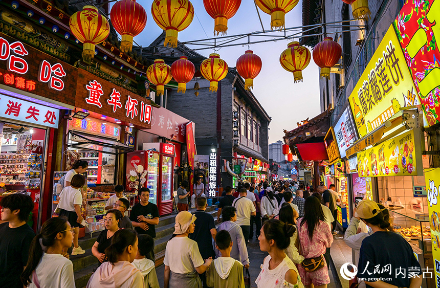 呼和浩特市玉泉區(qū)塞上老街旅游休閑街區(qū)“通順大巷夜市”人流如織。丁根厚攝