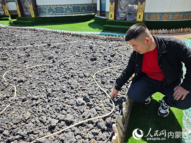 施金蓮的兒子正在介紹民宿里用火山石鋪就的觀賞區。人民網記者 劉藝琳攝