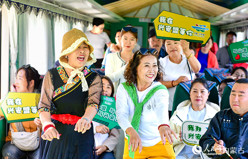 8月10日，游客在“阿爾山號”旅游專列上表演。王正攝