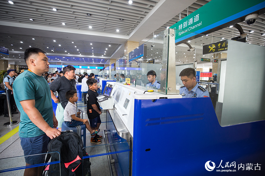 二連出入境邊防檢查站移民管理警察為旅客辦理通關(guān)手續(xù)。郭鵬杰攝