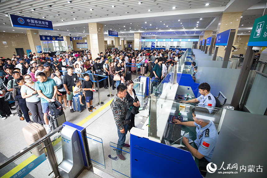 二連出入境邊防檢查站移民管理警察為旅客辦理通關(guān)手續(xù)。郭鵬杰攝