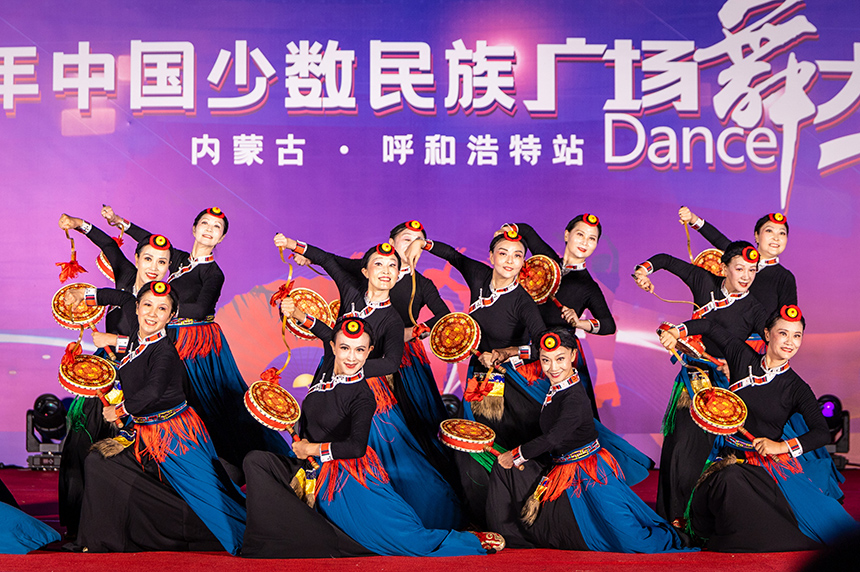 四川省成都市溫江區(qū)魚(yú)鳧藝術(shù)團(tuán)的隊(duì)員在表演廣場(chǎng)舞《雪域熱巴——鼓樂(lè)飛花》。丁根厚攝