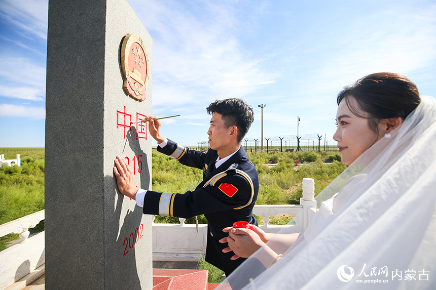 一對新人為日夜守護的界碑描紅。郭鵬杰攝