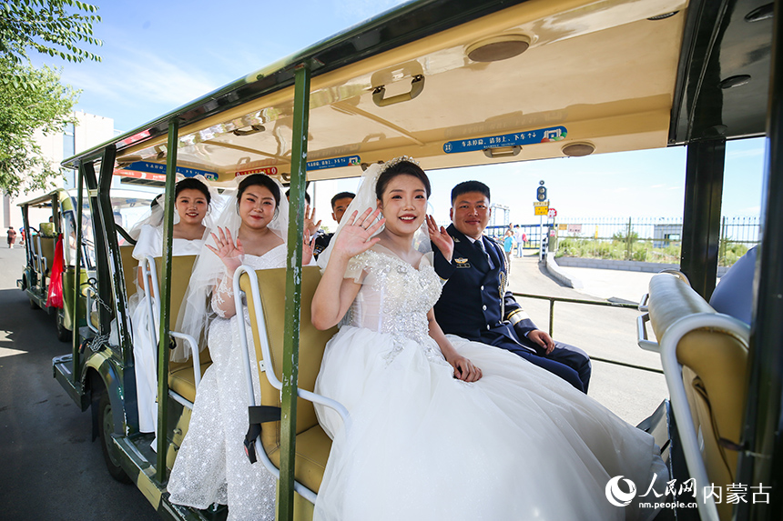 新人們乘坐電瓶車參加集體婚禮。郭鵬杰攝