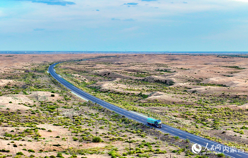 車輛在庫布其沙漠穿沙公路鄂爾多斯市杭錦旗段行駛。王正攝