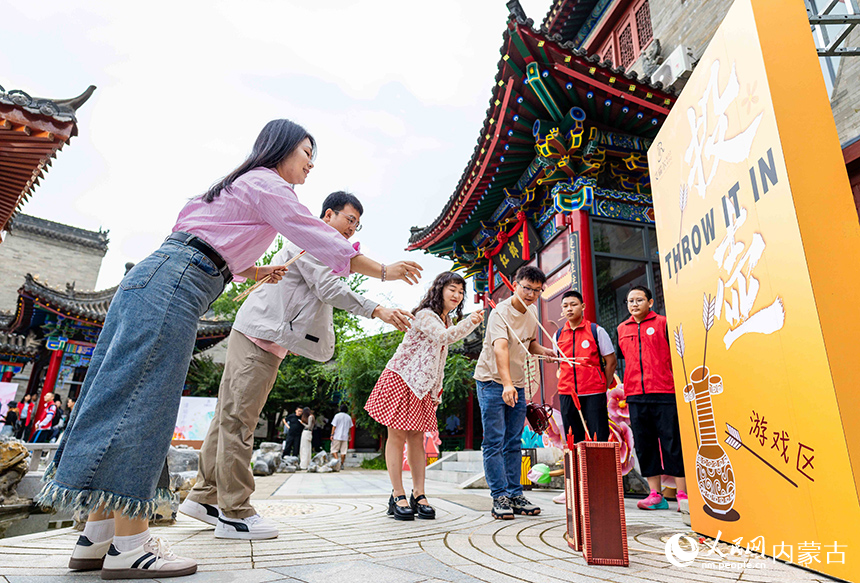 新人們在呼和浩特市玉泉區“我們的節日·七夕”主題活動現場體驗祈福投壺項目，感受傳統民俗文化魅力。丁根厚攝