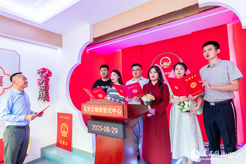 新人們在呼和浩特市玉泉區婚姻登記中心集體宣讀《文明婚嫁移風易俗承諾書》。丁根厚攝