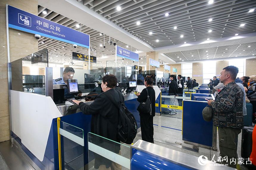 二連出入境邊防檢查站移民管理警察為旅客辦理入境手續(xù)。郭鵬杰攝