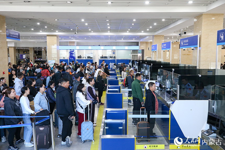 二連出入境邊防檢查站移民管理警察為旅客辦理入境手續。郭鵬杰攝