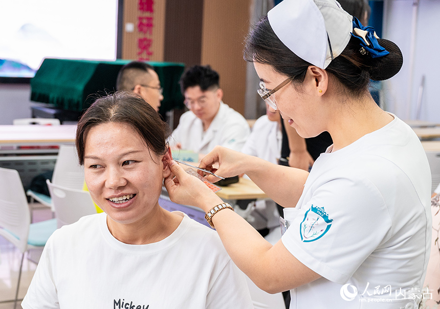 醫(yī)護(hù)人員在呼和浩特市玉泉區(qū)小召小學(xué)為老師們做耳穴貼壓治療。丁根厚攝