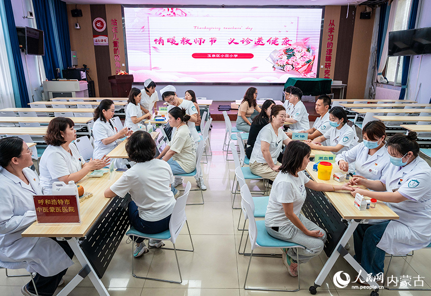 醫護人員在呼和浩特市玉泉區小召小學為老師們進行中醫蒙醫診療。丁根厚攝