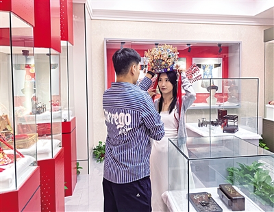 今年七夕，在呼和浩特市玉泉區婚俗博物館，新人試戴鳳冠。
