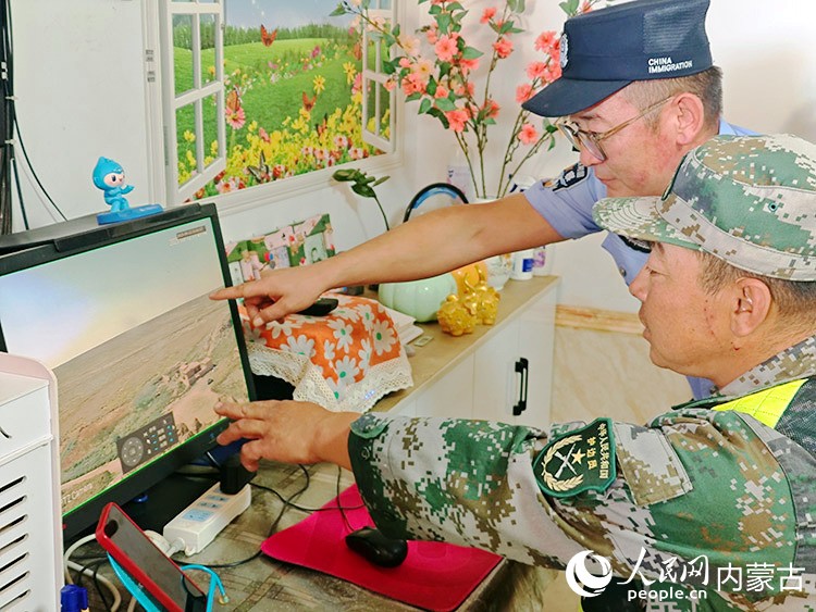 楊東和邊防民警正在從監控屏幕里觀察情況。人民網記者 劉藝琳攝