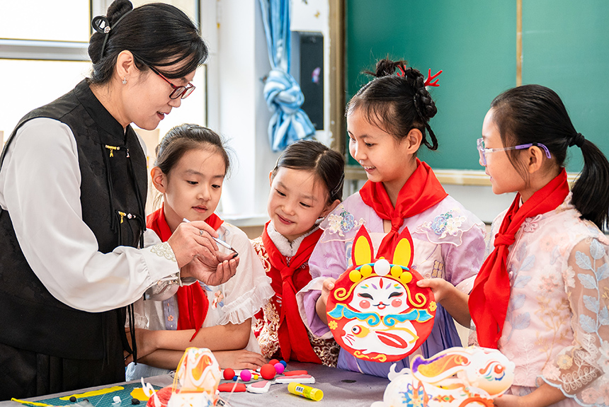內蒙古呼和浩特市玉泉區清泉街小學老師在中秋節主題活動上指導學生學做兔兒爺。丁根厚攝