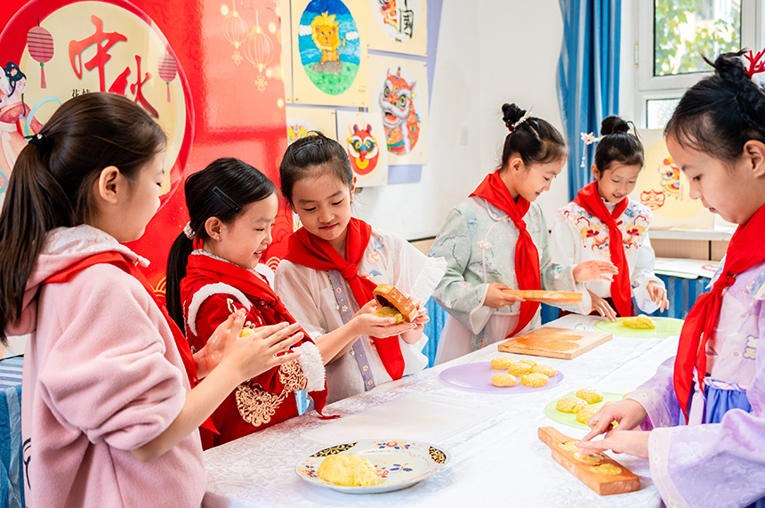 內蒙古呼和浩特市玉泉區清泉街小學學生在中秋節主題活動上學做月餅。丁根厚攝