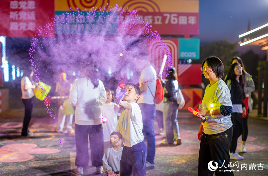10月2日晚，呼和浩特市玉泉區清嶼林夕房車營地，參加彩虹熒光跑活動的小朋友在現場揮灑彩粉嬉戲。丁根厚攝