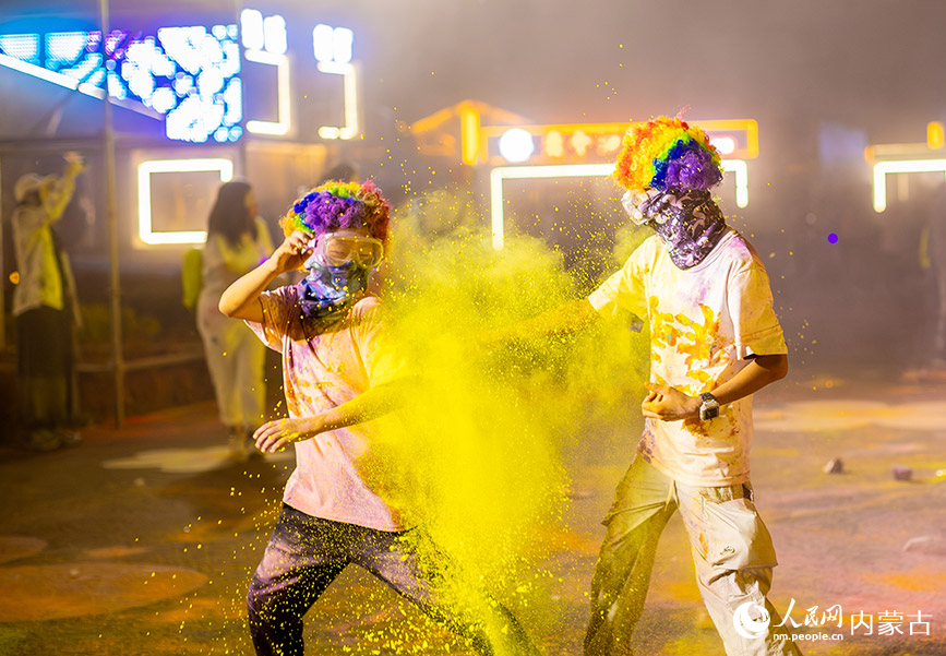 10月2日晚，呼和浩特市玉泉區清嶼林夕房車營地，參加彩虹熒光跑活動的小朋友在現場互噴彩粉嬉戲。丁根厚攝