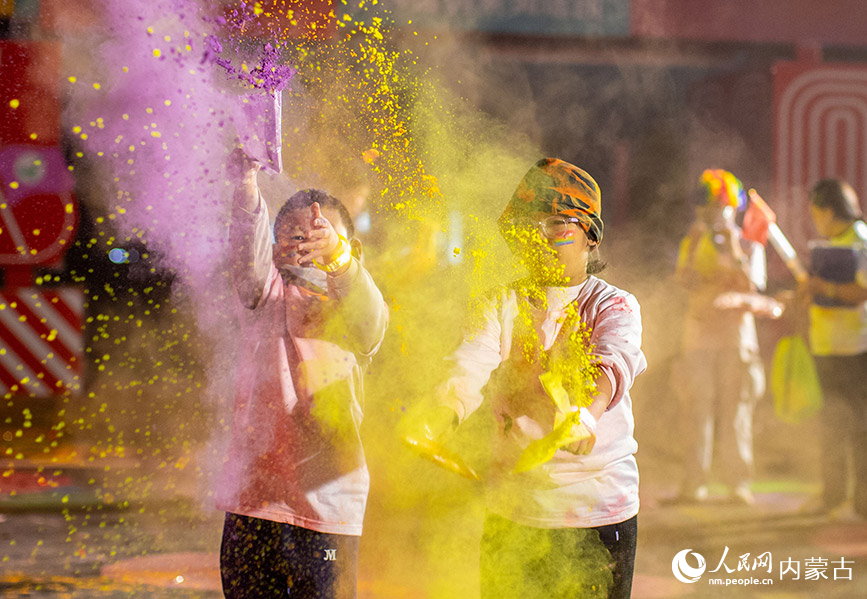 10月2日晚，呼和浩特市玉泉區清嶼林夕房車營地，參加彩虹熒光跑活動的小朋友在現場揮灑彩粉嬉戲。丁根厚攝