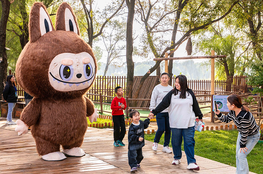 10月4日，呼和浩特市玉泉區林下郊野萌寵樂園，家長給孩子與拉布布人偶拍照留影。丁根厚攝