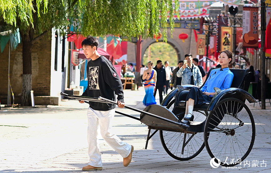 10月4日,游客在鄂爾多斯市伊金霍洛旗鄂爾多斯文化產(chǎn)業(yè)園體驗(yàn)洋車。王正攝