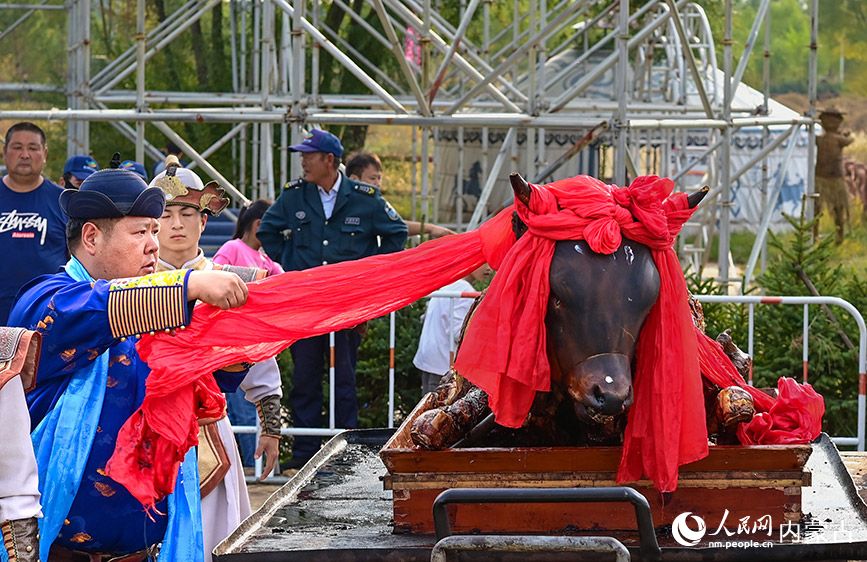 10月4日，民間藝人在鄂爾多斯市伊金霍洛旗鄂爾多斯文化產(chǎn)業(yè)園為烤全牛剪彩。王正攝