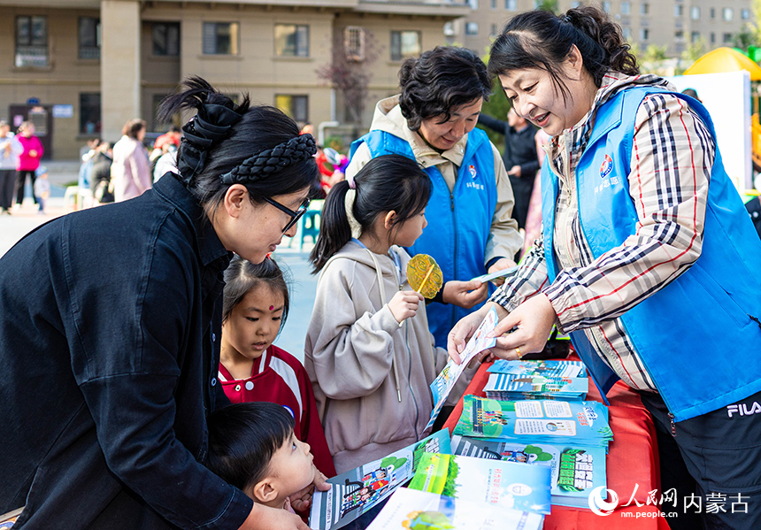 呼和浩特市玉泉區“文明市集”主題活動現場，科普志愿者在向居民普及科學知識。丁根厚攝