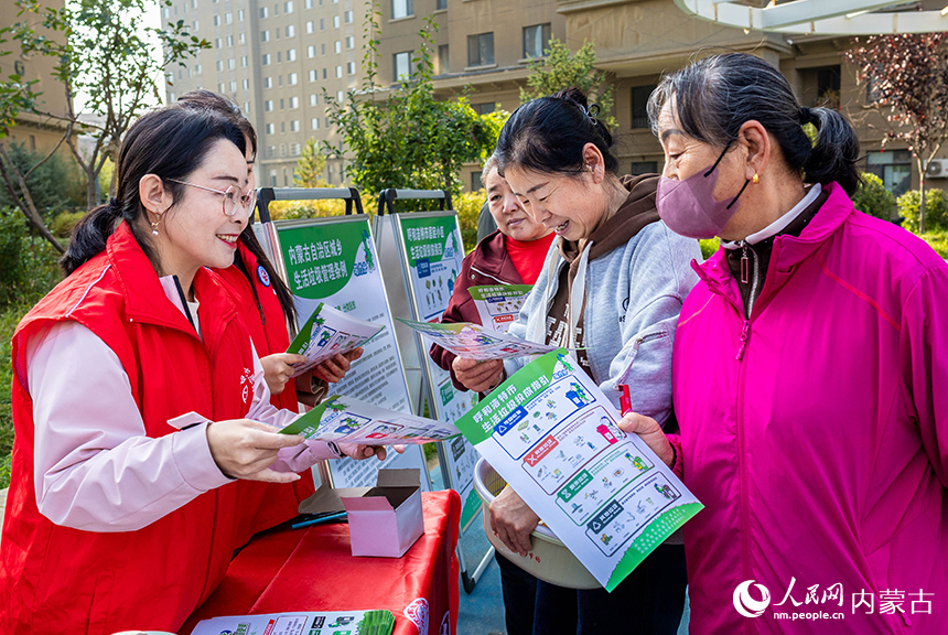 呼和浩特市玉泉區“文明市集”主題活動現場，志愿者向居民普及垃圾分類的相關知識。丁根厚攝
