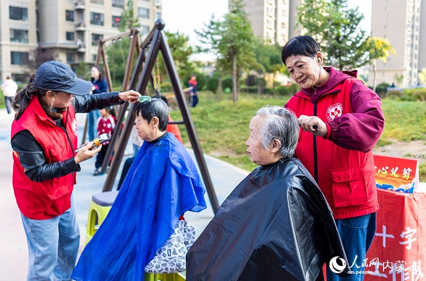 呼和浩特市玉泉區(qū)“文明市集”主題活動(dòng)現(xiàn)場(chǎng),內(nèi)蒙古紅十字仁愛(ài)媽媽志愿服務(wù)隊(duì)隊(duì)員為居民義剪。丁根厚攝