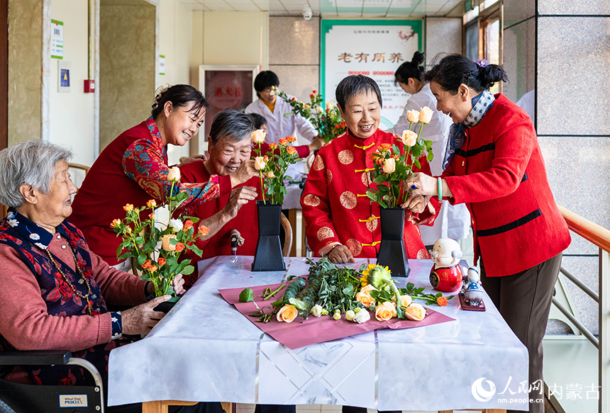 老人們在呼和浩特市玉泉區(qū)民政局“愛心敬老 情暖重陽”主題活動現(xiàn)場體驗插花花藝。丁根厚攝